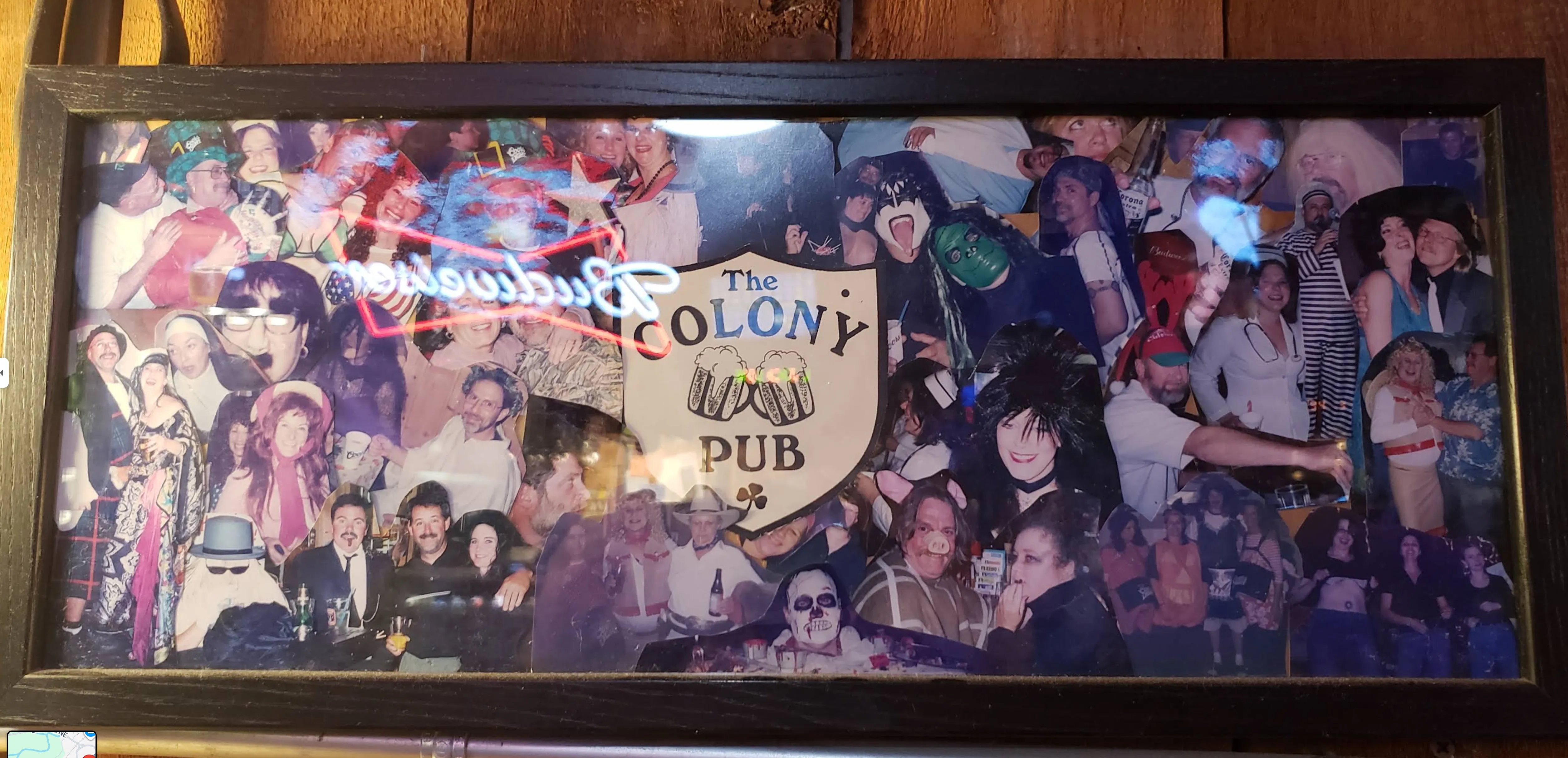 A framed collage of decades of pub costume parties and events surrounding the Colony Pub crest.